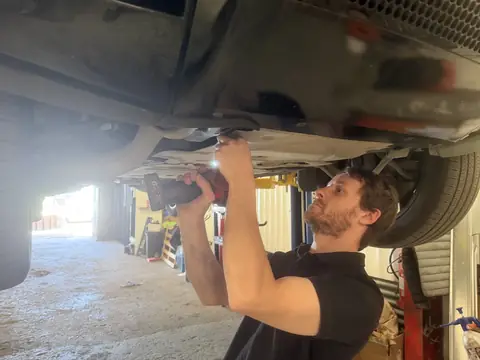 Russ working on the underside of a car on the workshop ramp at RPM Autocare, Newton Abbot